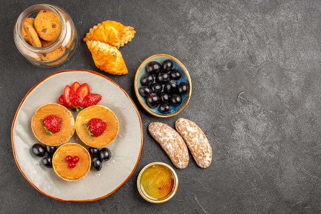 Draufsicht leckere Pfannkuchen mit Obst und Kuchen im Dunkeln