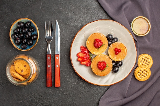 Draufsicht leckere Pfannkuchen mit Oliven und Früchten im Dunkeln