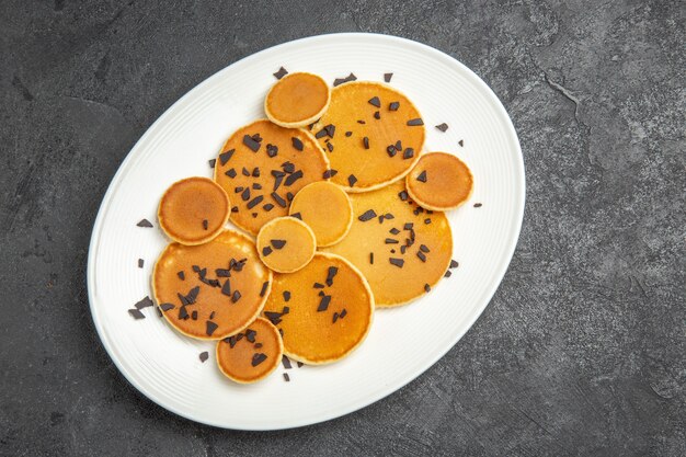 Draufsicht leckere Pfannkuchen mit Schoko-Chips auf dem dunklen Hintergrund