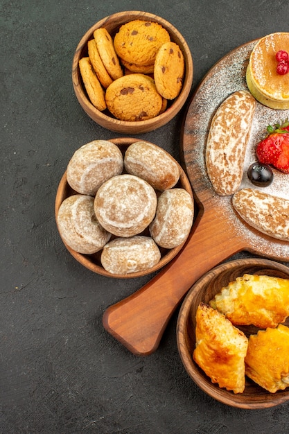 Draufsicht leckere Pfannkuchen mit verschiedenen Süßigkeiten auf dem dunklen Oberflächenzuckerkuchen-Dessert