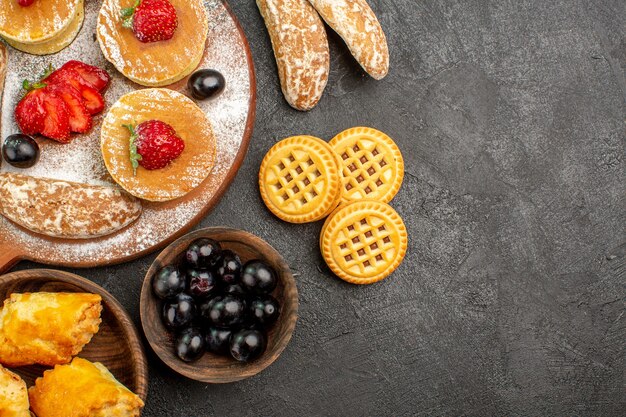 Draufsicht leckere Pfannkuchen mit verschiedenen Süßigkeiten auf dunklem Boden Zuckerkuchen Dessert