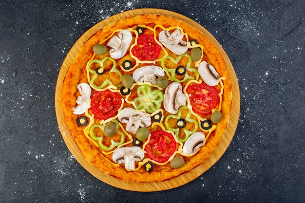 Draufsicht leckere Pilzpizza mit roten Tomaten, Paprika, Oliven und Pilzen, alle innen auf dem grauen Schreibtisch Essen Mahlzeit Pizza Italienisch geschnitten