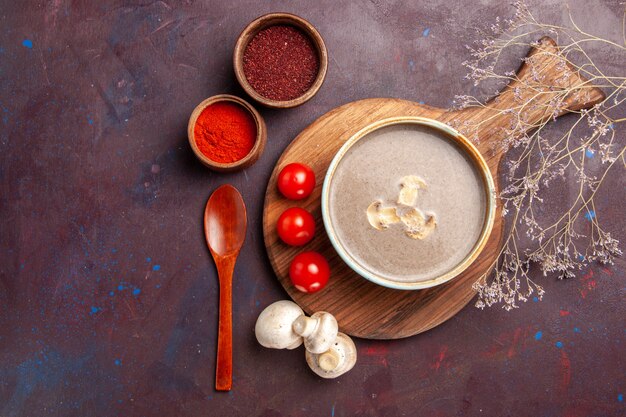 Draufsicht leckere Pilzsuppe mit verschiedenen Gewürzen auf dunklem Hintergrund Suppenmahlzeit Pilzgewürznahrung