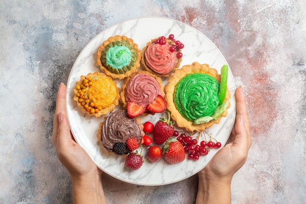 Draufsicht leckere Sahnekuchen mit Früchten auf leichtem Tischkeksdessert süßer Kuchen