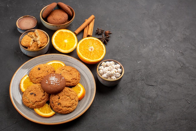 Draufsicht leckere Sandkekse mit frisch geschnittenen Orangen auf dunklem Hintergrund Obstkeks süßer Keks Zitruszucker