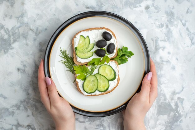 Draufsicht leckere Sandwiches mit Gurken und Oliven im Teller auf weißem Hintergrund Essen Gesundheit Mahlzeit Brot Mittagessen horizontaler Toast Burger