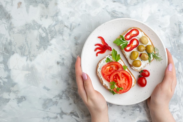Draufsicht leckere Sandwiches mit Tomaten und Oliven auf weißem Hintergrund Essen Gesundheit Mahlzeit Brot horizontaler Toast Burger