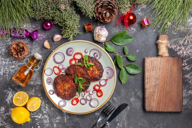 Draufsicht leckere Schnitzel mit Zwiebelringen auf dem grauen Hintergrund Fleischgericht Mahlzeit Foto