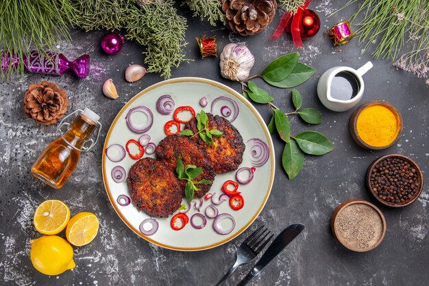 Draufsicht leckere Schnitzel mit Zwiebelringen auf dem grauen Hintergrund Fleischgericht Mahlzeit Foto