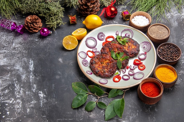 Draufsicht leckere Schnitzel mit Zwiebelringen auf dem grauen Hintergrundgericht Fleischmehlfoto