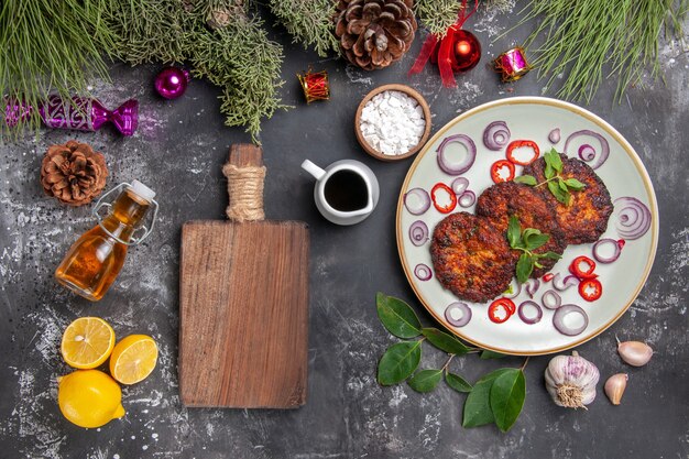 Draufsicht leckere Schnitzel mit Zwiebelringen auf dem grauen Hintergrundgericht Mahlzeit Foto Fleisch