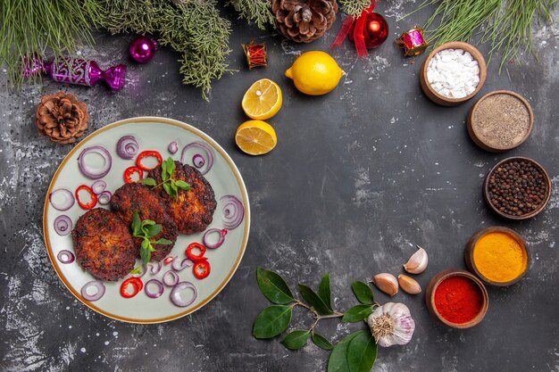 Draufsicht leckere Schnitzel mit Zwiebelringen auf dem grauen Hintergrundmahlzeitfotoschalenfleisch