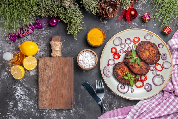 Draufsicht leckere Schnitzel mit Zwiebelringen auf dem hellgrauen Hintergrundmahlzeitfoto-Fleischgericht