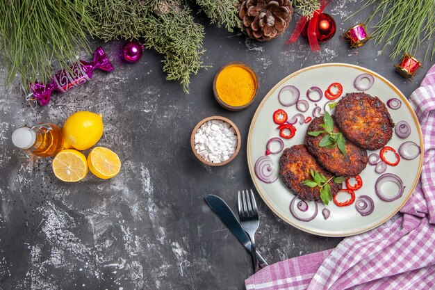 Draufsicht leckere Schnitzel mit Zwiebelringen auf dem hellgrauen Hintergrundmahlzeitfoto-Fleischgericht