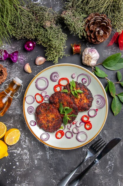 Draufsicht leckere Schnitzel mit Zwiebelringen auf grauem Schreibtisch Fleischgericht Mahlzeit Foto