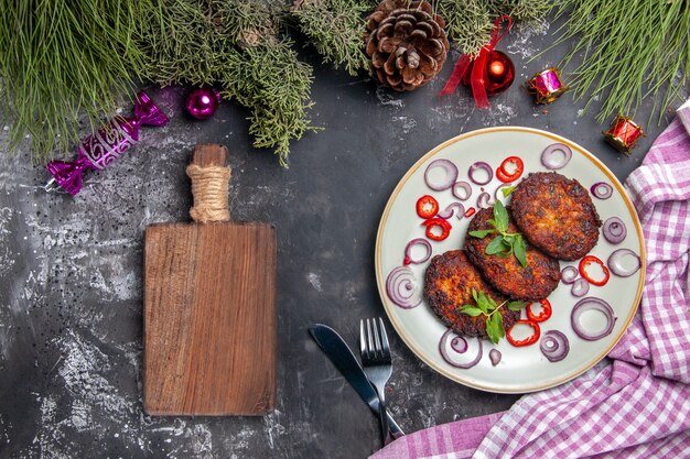 Draufsicht leckere Schnitzel mit Zwiebelringen auf hellgrauem Hintergrundfleischschalenfoto