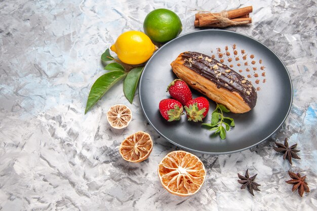 Draufsicht leckere Schoko-Eclairs mit Erdbeeren auf leichtem Dessertkuchen-Keks