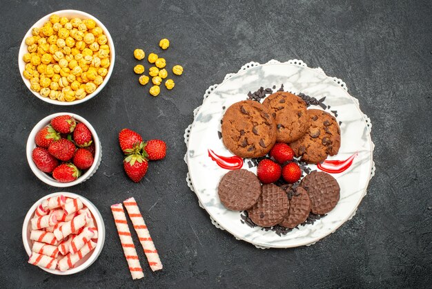 Draufsicht leckere Schoko-Kekse mit Bonbons auf dunklem Hintergrund süßer Zuckerkuchen-Keks