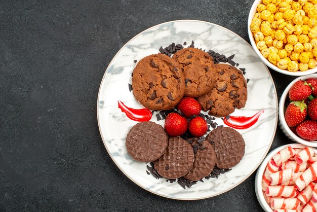 Draufsicht leckere Schoko-Kekse mit Süßigkeiten auf dunklem Hintergrund Zuckerkuchen süßer Keks