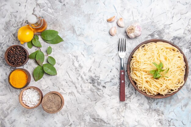 Draufsicht leckere Spaghetti mit Gewürzen auf dem weißen Teiggericht Pasta