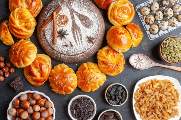 Draufsicht leckere süße Brötchen mit Nüssen und Rosinen auf dunklem Hintergrund