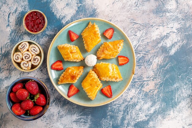 Draufsicht leckere süße Kuchen mit Früchten auf blauem Hintergrund