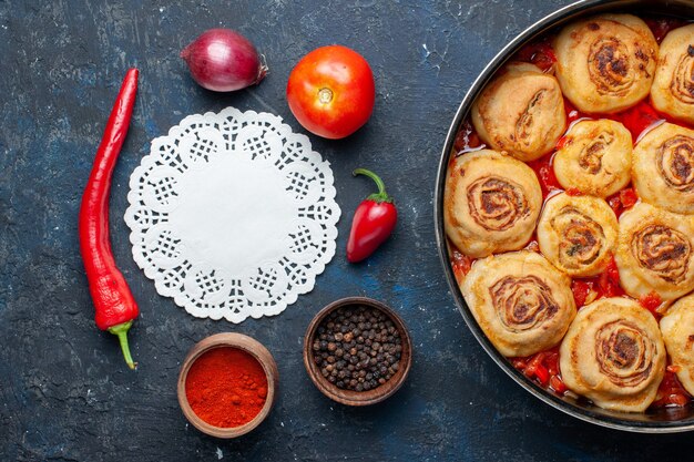 Draufsicht leckere Teigmahlzeit mit Fleisch in der Pfanne zusammen mit frischem Gemüse wie Zwiebeltomaten auf dem dunkelgrauen Schreibtischessenmehl Fleischgemüse