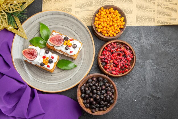 Draufsicht leckere Waffelkuchen mit frischen Früchten auf dunklem Schreibtisch