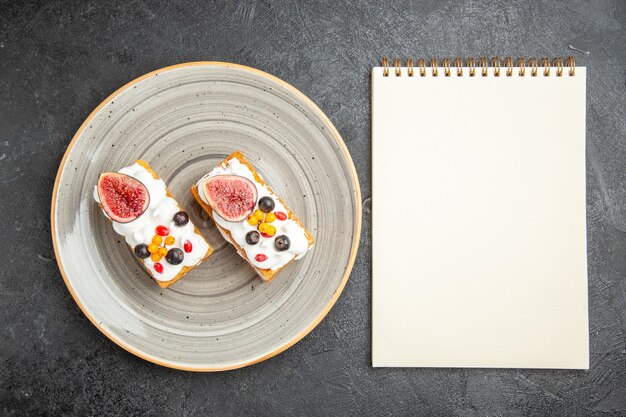 Kostenloses Foto draufsicht leckere waffelkuchen mit früchten auf dem dunklen hintergrund