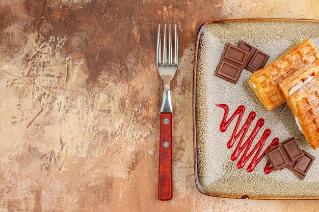 Draufsicht leckere Waffelkuchen mit Schokoriegeln auf braunem Hintergrund