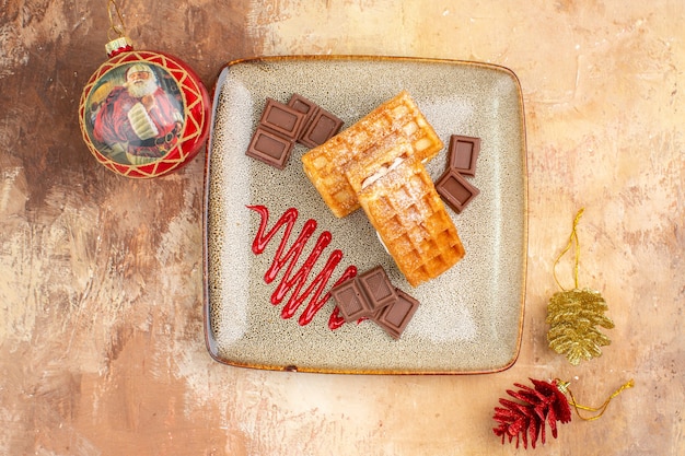 Draufsicht leckere Waffelkuchen mit Schokoriegeln auf braunem Hintergrund