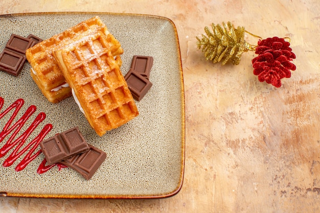 Draufsicht leckere Waffelkuchen mit Schokoriegeln auf braunem Hintergrund