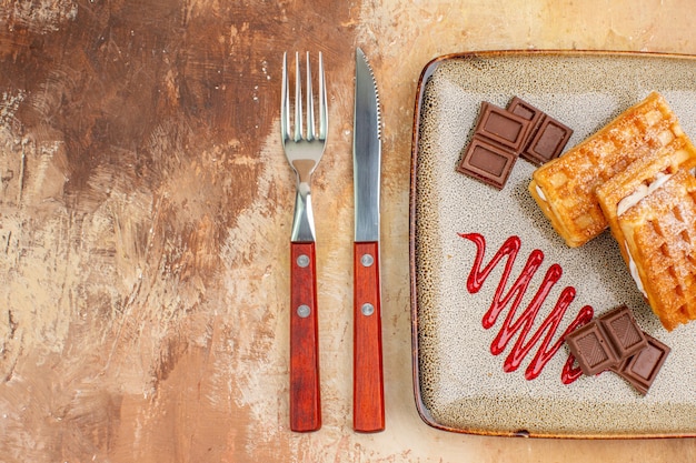 Draufsicht leckere Waffelkuchen mit Schokoriegeln auf braunem Hintergrund