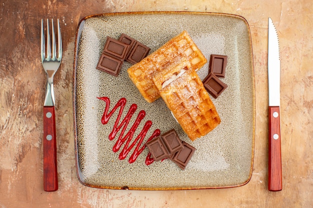 Draufsicht leckere Waffelkuchen mit Schokoriegeln auf braunem Hintergrund