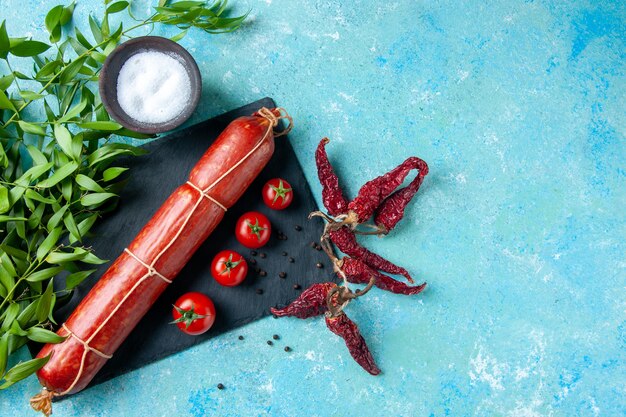 Draufsicht leckere Wurst mit roten Tomaten auf hellblauem Hintergrund Farbe Lebensmittel Burger Mahlzeit Sandwich Brot