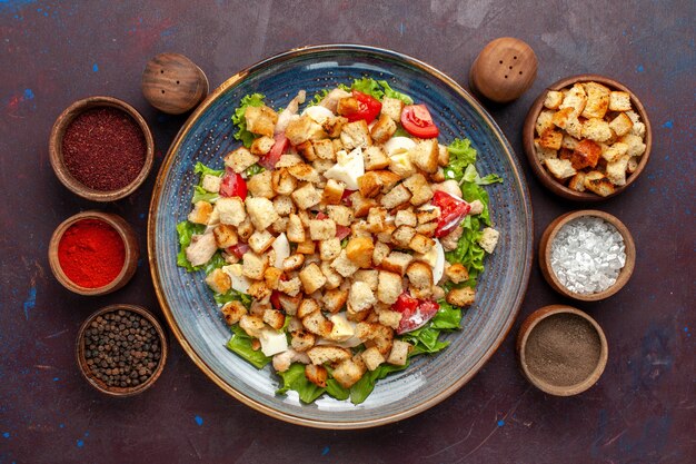 Draufsicht leckeren Caesar Salat mit Gewürzen auf dunkler Oberfläche