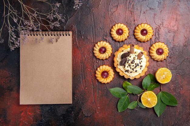 Kostenloses Foto draufsicht leckeren cremigen kuchen mit keksen auf dem dunklen tischdessert süßer kekskuchen