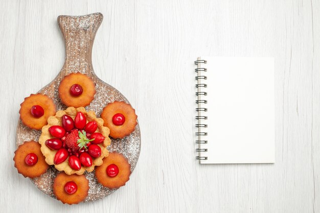 Draufsicht leckeren cremigen Kuchen mit Kuchen und Früchten auf weißem Schreibtisch