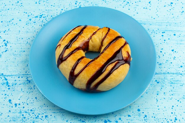 Draufsicht leckeren Donut mit Schokolade innerhalb der blauen Platte auf dem hellblauen Boden