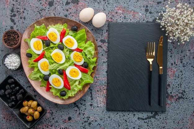 Draufsicht leckeren Eiersalat mit grünem Salat und Oliven auf hellem Hintergrund