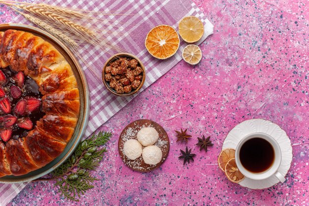 Draufsicht leckeren Erdbeerkuchen fruchtigen Kuchen mit Tee auf rosa