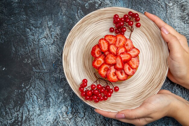 Draufsicht leckeren Erdbeerkuchen mit roten Beeren auf dunklem Schreibtisch