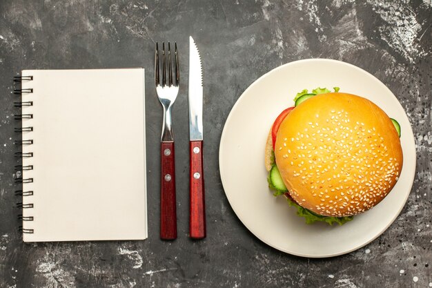 Draufsicht leckeren Fleischburger mit Gemüse auf der dunklen Oberfläche Brötchensandwich-Fastfood