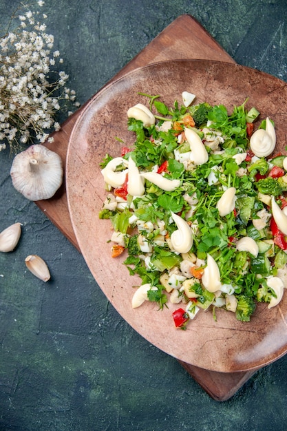 Draufsicht leckeren Gemüsesalat innerhalb Platte auf dunkelblauem Hintergrund Restaurantküche Abendessen Mahlzeit Mittagessen Gesundheit fit Küche Farbe