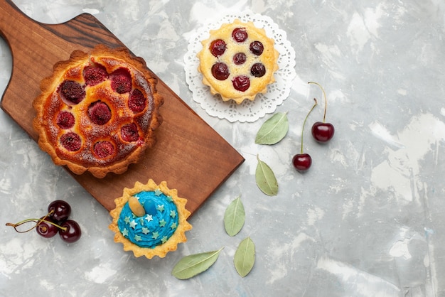 Draufsicht leckeren Himbeerkuchen mit Kuchen und frischen Sauerkirschen auf dem hellen Hintergrundkuchen backen Obstkuchen