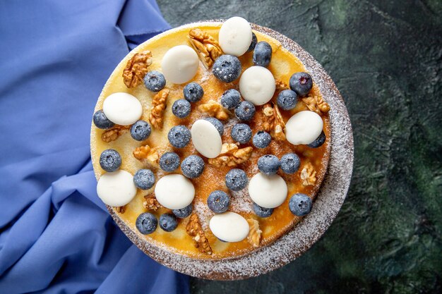 Draufsicht leckeren Kuchen mit Walnüssen Blaubeeren und Keksen dunkle Oberfläche