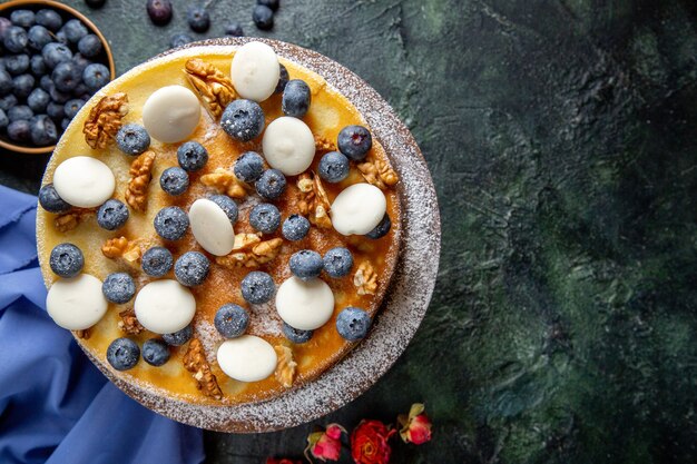 Draufsicht leckeren Kuchen mit Walnüssen Blaubeeren und Keksen dunkle Oberfläche