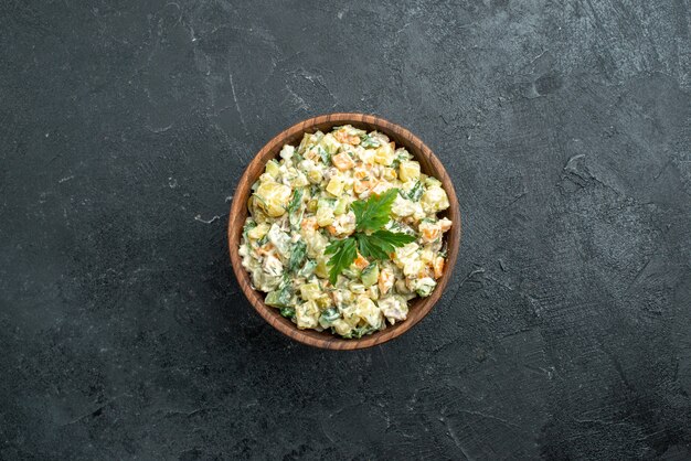 Draufsicht leckeren Mayonaonaise-Salat innerhalb der braunen Platte auf Schwarz