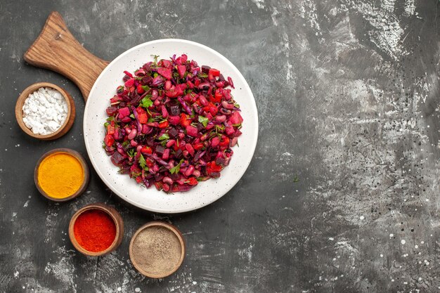 Kostenloses Foto draufsicht leckeren vinaigrette-salat mit gewürzen auf der grauen oberfläche