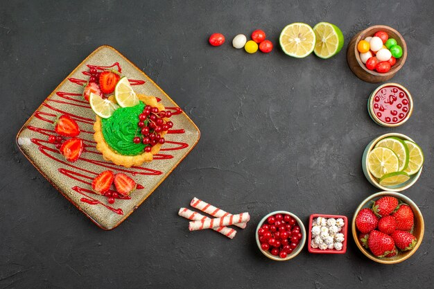 Draufsicht leckerer cremiger Kuchen mit Früchten auf dem grauen Hintergrunddessertfarbkeks süß